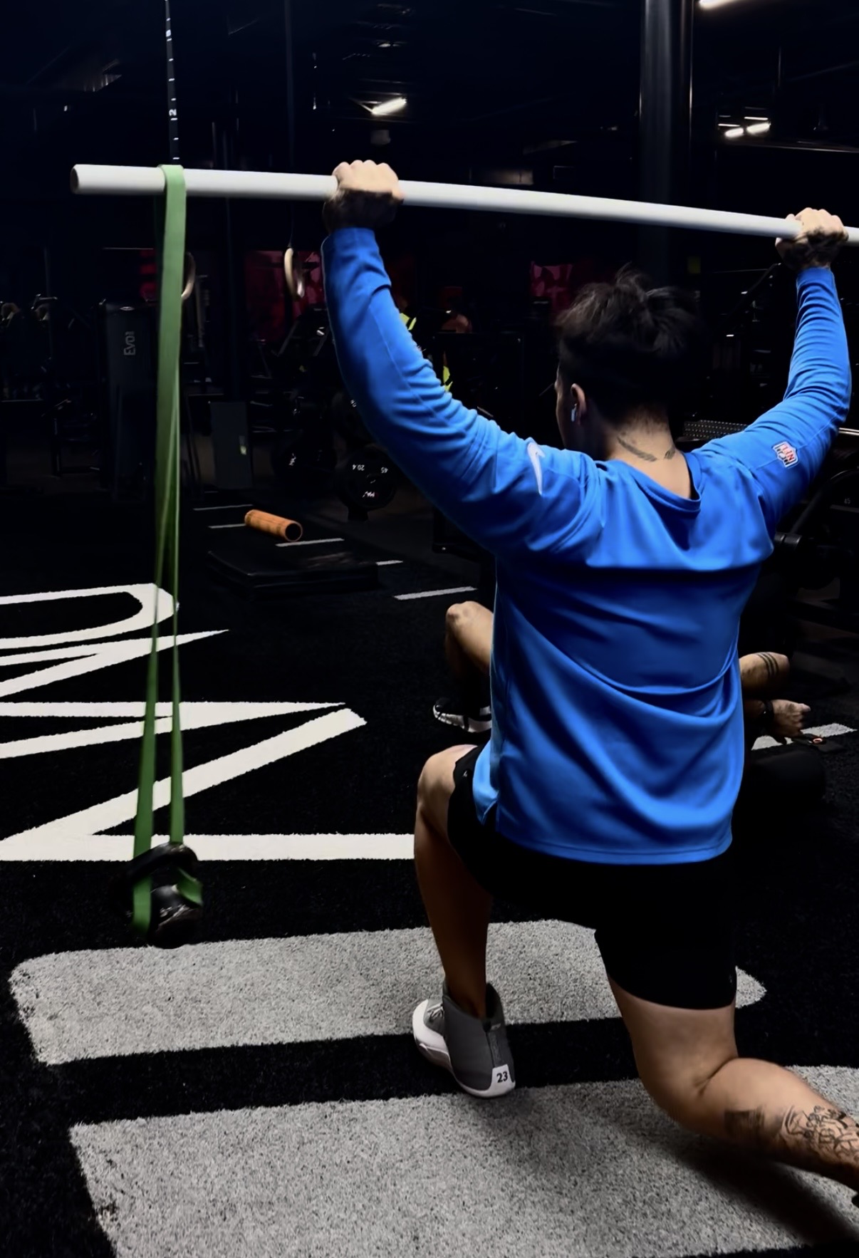 Joseph Achour coaching an overhead barbell movement in a gym
